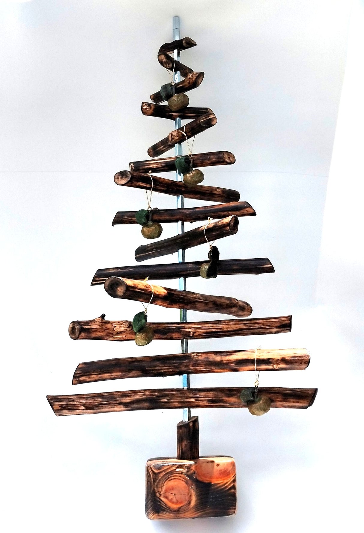 Escultura de árbol hecha con ramas carbonizadas mediante la técnica Yakisugi y decorada con manzanas Ibarbi de pasta de papel, de la Serie Elemental por Isabel Nobre