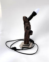  Lámpara de diseño Sentinela con tronco de madera flotante carbonizada Yakisugi sobre base metálica cuadrada de estilo industrial.