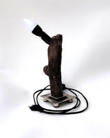  Lámpara de diseño Sentinela con tronco de madera flotante carbonizada Yakisugi sobre base metálica cuadrada de estilo industrial.