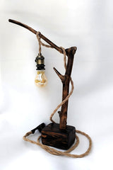 Lámpara de mesa artesanal Raiz de Luz hecha de madera flotante carbonizada Yakisugi y cable de cuerda de yute sobre fondo blanco.