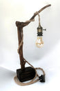 Lámpara de mesa artesanal Raiz de Luz hecha de madera flotante carbonizada Yakisugi y cable de cuerda de yute sobre fondo blanco.