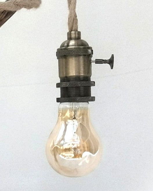Lámpara de mesa artesanal Raiz de Luz hecha de madera flotante carbonizada Yakisugi y cable de cuerda de yute sobre fondo blanco.