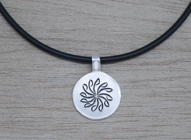 Producto vasco colgante BIRA grande de plata con cordón caucho mitología vasca artesanía TXUS GRUZETA.