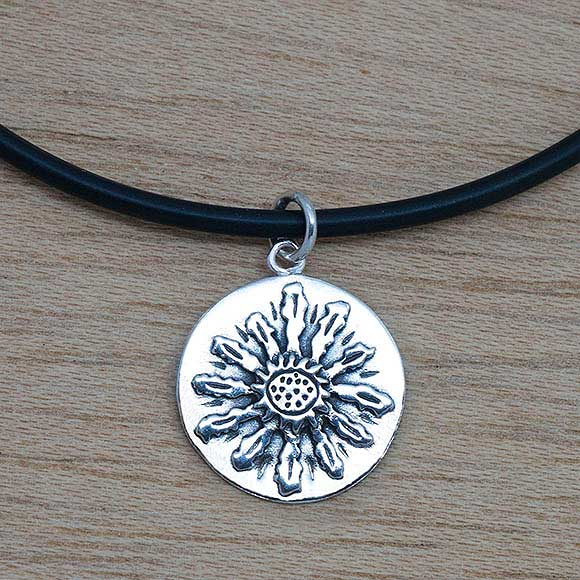 Producto vasco colgante EGUZKILORE de plata sobre base cordón de caucho mitología vasca artesanía TXUS GRUZETA